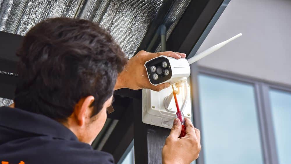 An image of a man installing a wireless security camera